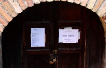 Notice of closure on the doors of the Arian Baptistery one of Ravenna's sights with individual tickets
