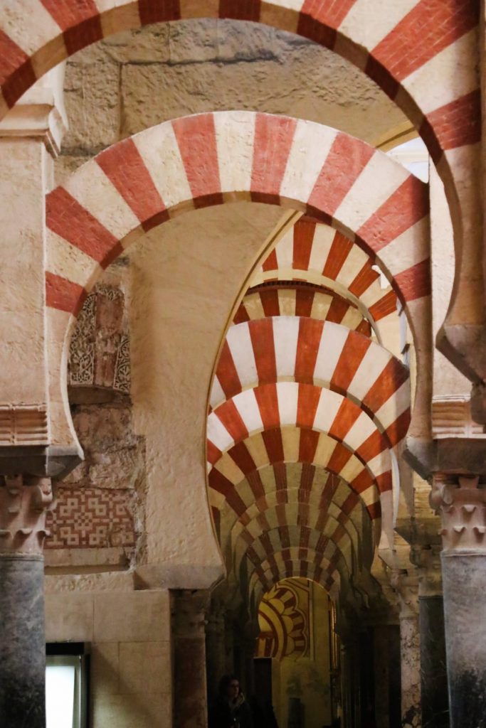 White-and-red horseshoe-shaped arches in the Mezquita Mosque-Cathedral in Cordoba