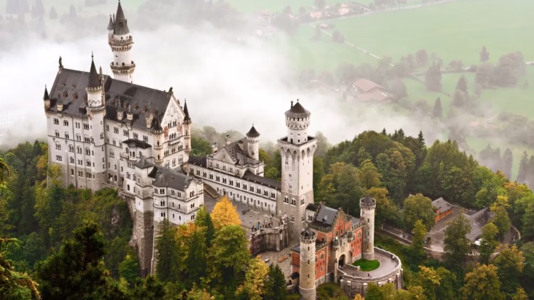Visit Schloss Neuschwanstein Castle shrouded in mist in the Bavarian Alps of Germany.